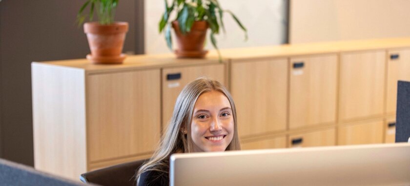 En smilende elev sittende i en resepsjon - Klikk for stort bilde